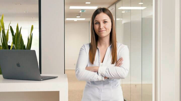 Eine Frau steht vor einem Laptop in einem Büro.